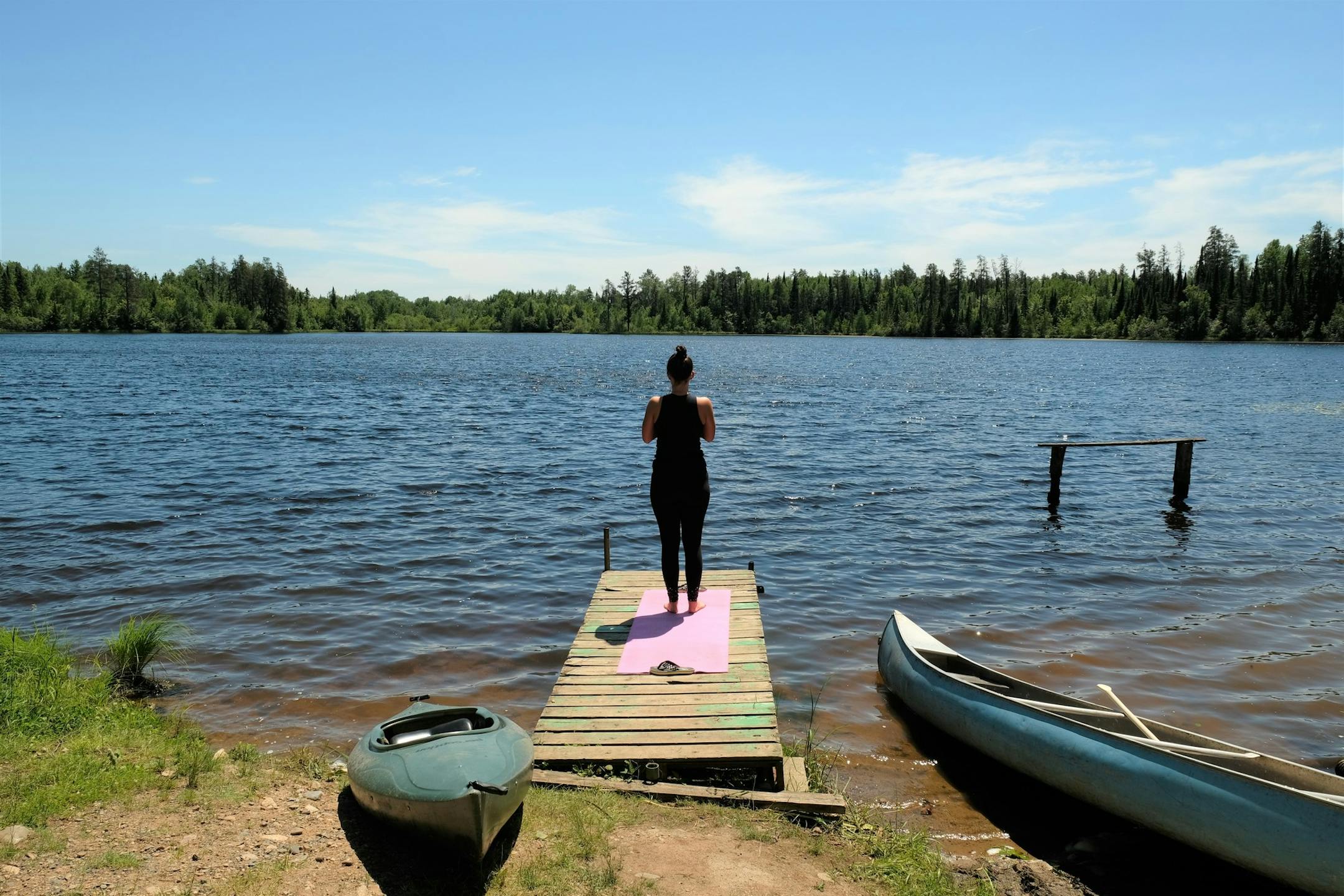 A woman stands near a lake at Mesaba Co-op Park on Friday, June 21, 2019 near Hibbing, Minnesota. (Jenna Ross/Star Tribune)