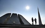 A couple walk at the Tzitzernakaberd memorial to the victims of mass killings by Ottoman Turks, in the Armenian capital Yerevan, Armenia, Wednesday, O