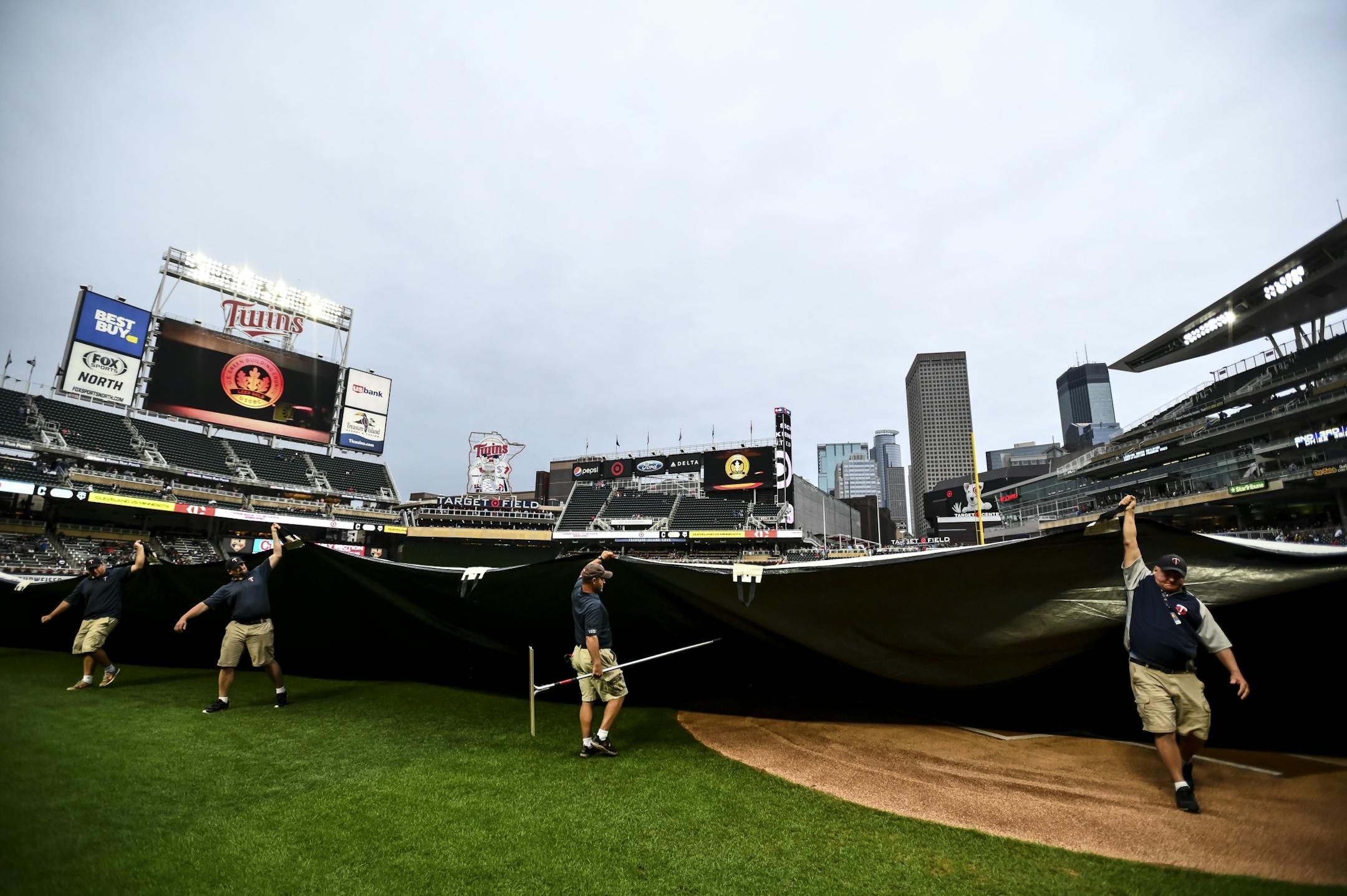 The Twins grounds crew moved the tarp during Saturday night's rain delay at Target Field.