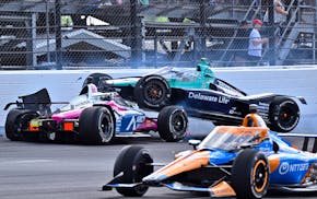 Marcus Ericsson (28) goes over the top of Tom Blomqvist as the collide in the first turn during the Indianapolis 500 on Sunday.