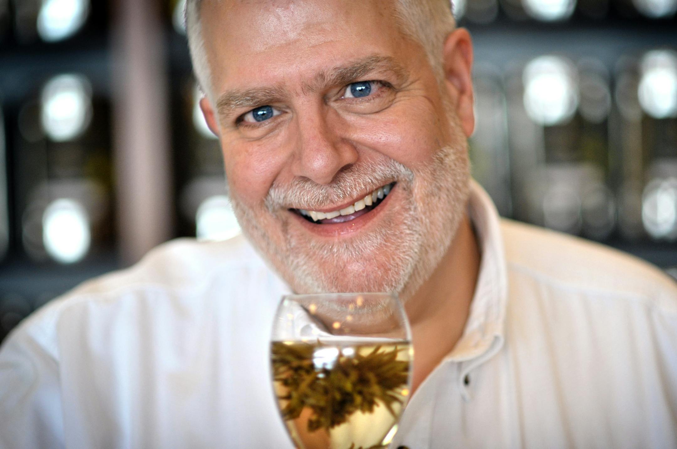 GLEN STUBBE • gstubbe@startribune.com -- Tuesday, January 2, 2010 -- St. Anthony, Minn. -- ] Bill Waddington, tea merchant and owner of Tea Source in St Anthony, Minn. held a glass of Red Flower Jasmine tea which has individual tea leaves tied together with a silk thread forming a blossom when water is added.