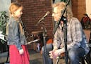 Greta Sloan, 8, gets some pre-performance advice from Mike Arturi as she prepares to play guitar and sing at a concert at Universal Music Center