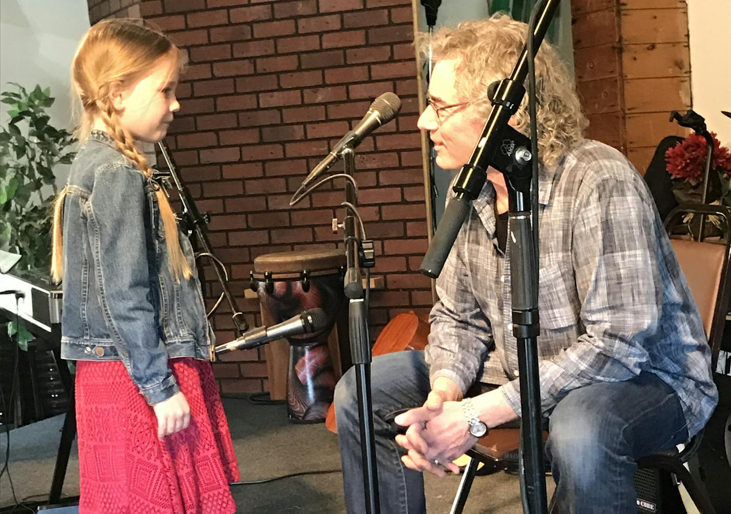 Greta Sloan, 8, gets some pre-performance advice from Mike Arturi as she prepares to play guitar and sing at a concert at Universal Music Center