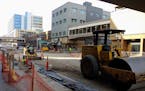 Workers prepared a section of W. Superior Street in downtown Duluth to be covered in asphalt through the winter before work on a permanent surface is 