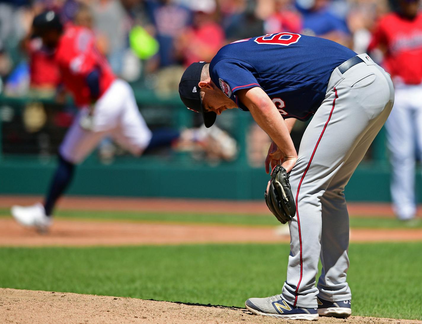 Minnesota Twins relief pitcher Trevor May, foreground, waits for Cleveland Indians' Carlos Santana to run the bases after hitting a solo home run in the seventh inning of a baseball game, Sunday, July 14, 2019, in Cleveland. (AP Photo/David Dermer)