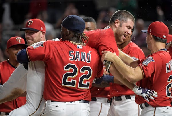 Minnesota Twins third baseman Miguel Sano (22) lifted first baseman Joe Mauer up on his shoulder after Mauer hit a walk off homerun in the bottom of t