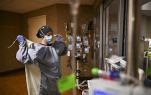 North Memorial Health Hospital critical care nurse Kayla Lynch donned a protective gown before entering the room of a COVID-19 patient during her shif