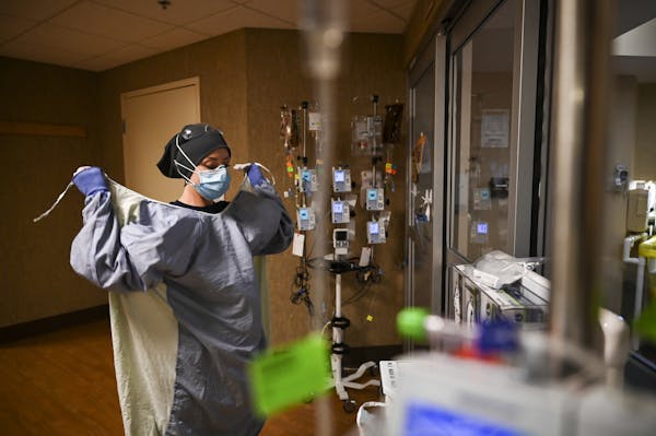 North Memorial Health Hospital critical care nurse Kayla Lynch donned a protective gown before entering the room of a COVID-19 patient during her shif