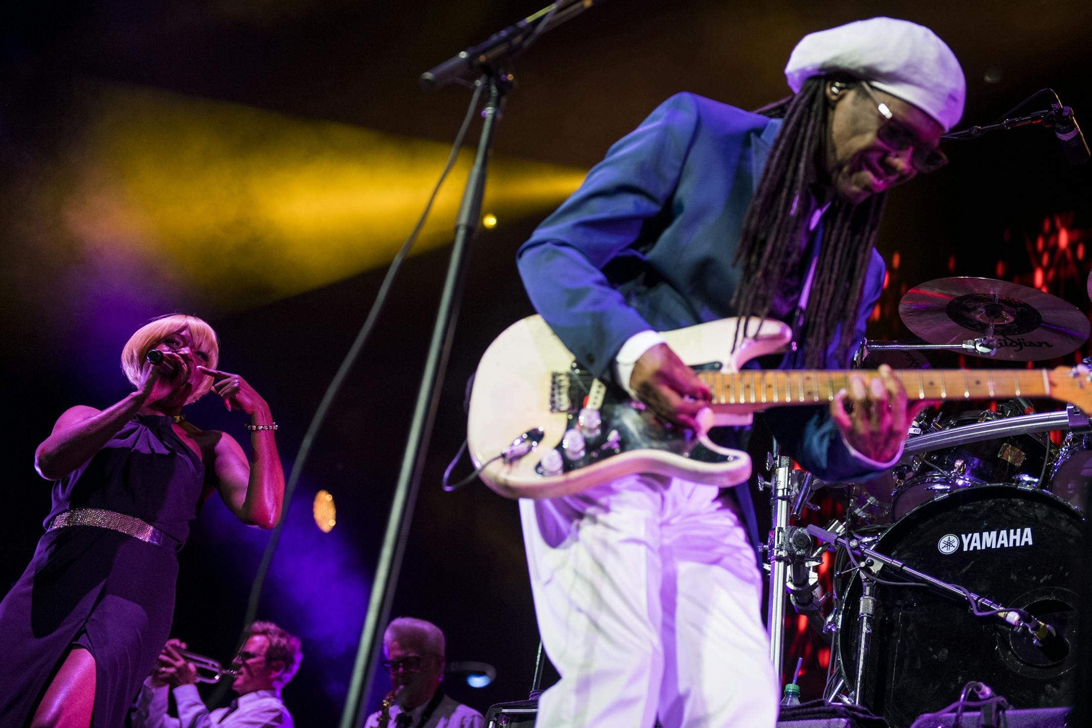 Nile Rodgers of Chic, right, played guitar as a vocalist sang a solo at the Xcel Energy Center on Saturday night.