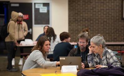 In February, Elizabeth McNamara, left, offered her assistance to Steve and Nancy Gehrenbeck-Miller as they began filling out the FAFSA form online dur