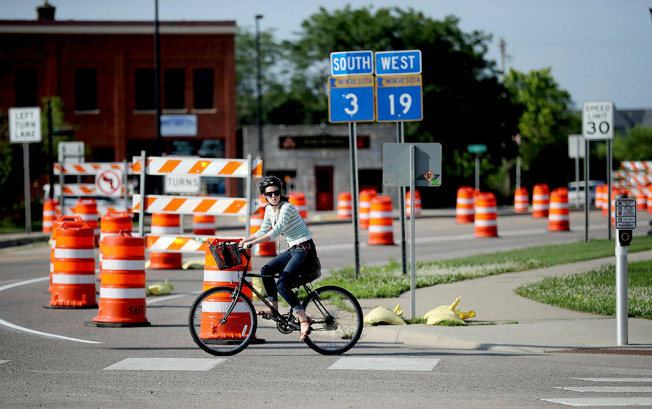 A bicyclist made her way across a very busy 2nd Street West, Monday, June 13, 2016 in Northfield, MN. The Northfield intersection now has radar installed on the arm of one traffic signal to recognize bicyclists and give them more time to cross the street. The radar is part of a MNDOT pilot project. ] (ELIZABETH FLORES/STAR TRIBUNE) ELIZABETH FLORES • eflores@startribune.com