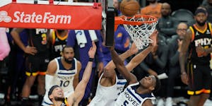 Suns guard Devin Booker (1) has his shot defended by Wolves guard Anthony Edwards (5) during the second half of Sunday night's playoff game in Phoenix