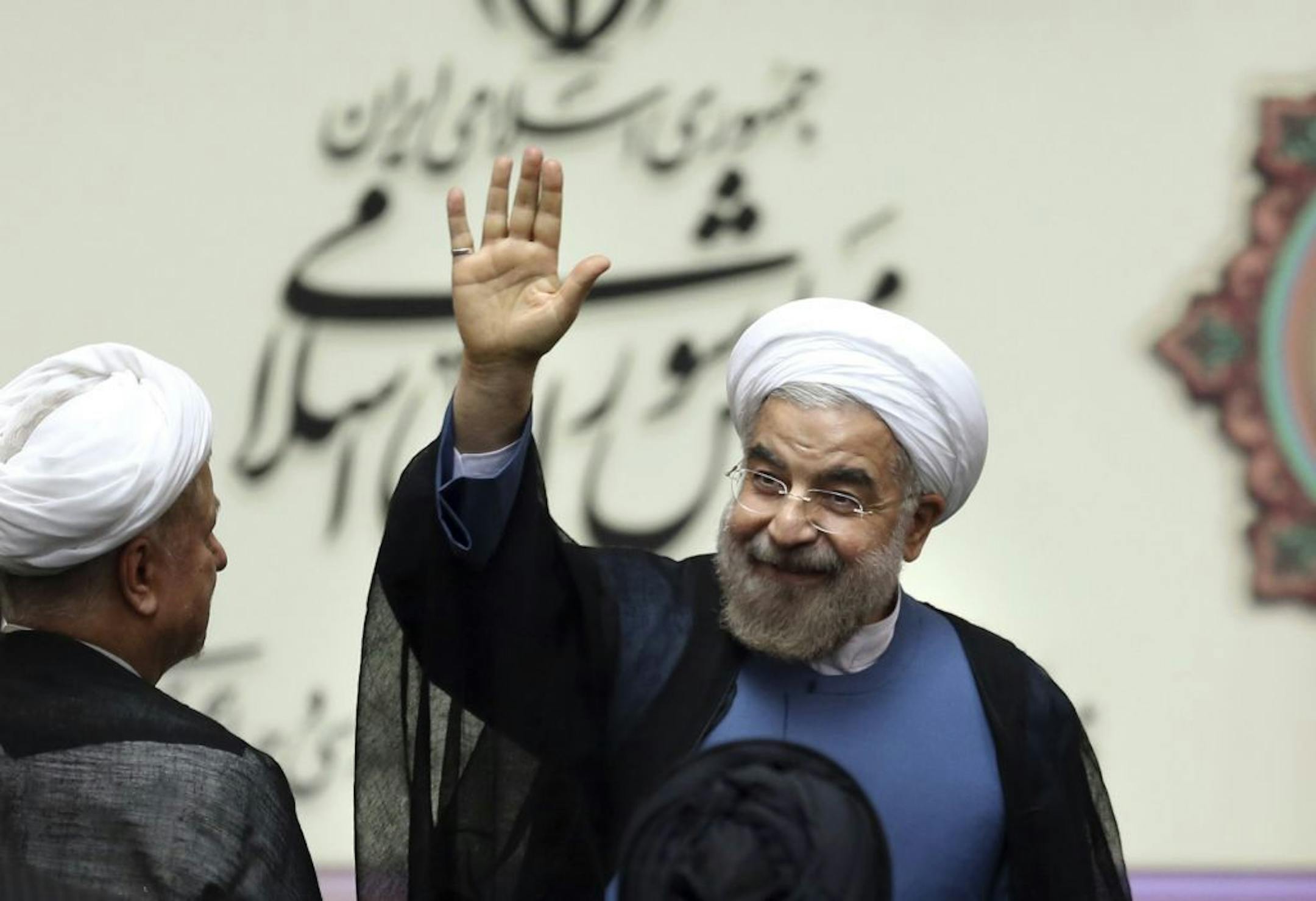 Iran's new President Hasan Rouhani, waves after swearing in at the parliament, in Tehran, Iran, Sunday, Aug. 4, 2013. Iran's new president on Sunday called on the West to abandon the "language of sanctions" in dealing with his country over its contentious nuclear program, hoping to ease the economic pressures now grinding its people. Rouhani spoke after being sworn in as president in an open session of parliament Sunday, capping a weekend that saw him endorsed by Ayatollah Ali Khamenei, Iran's s