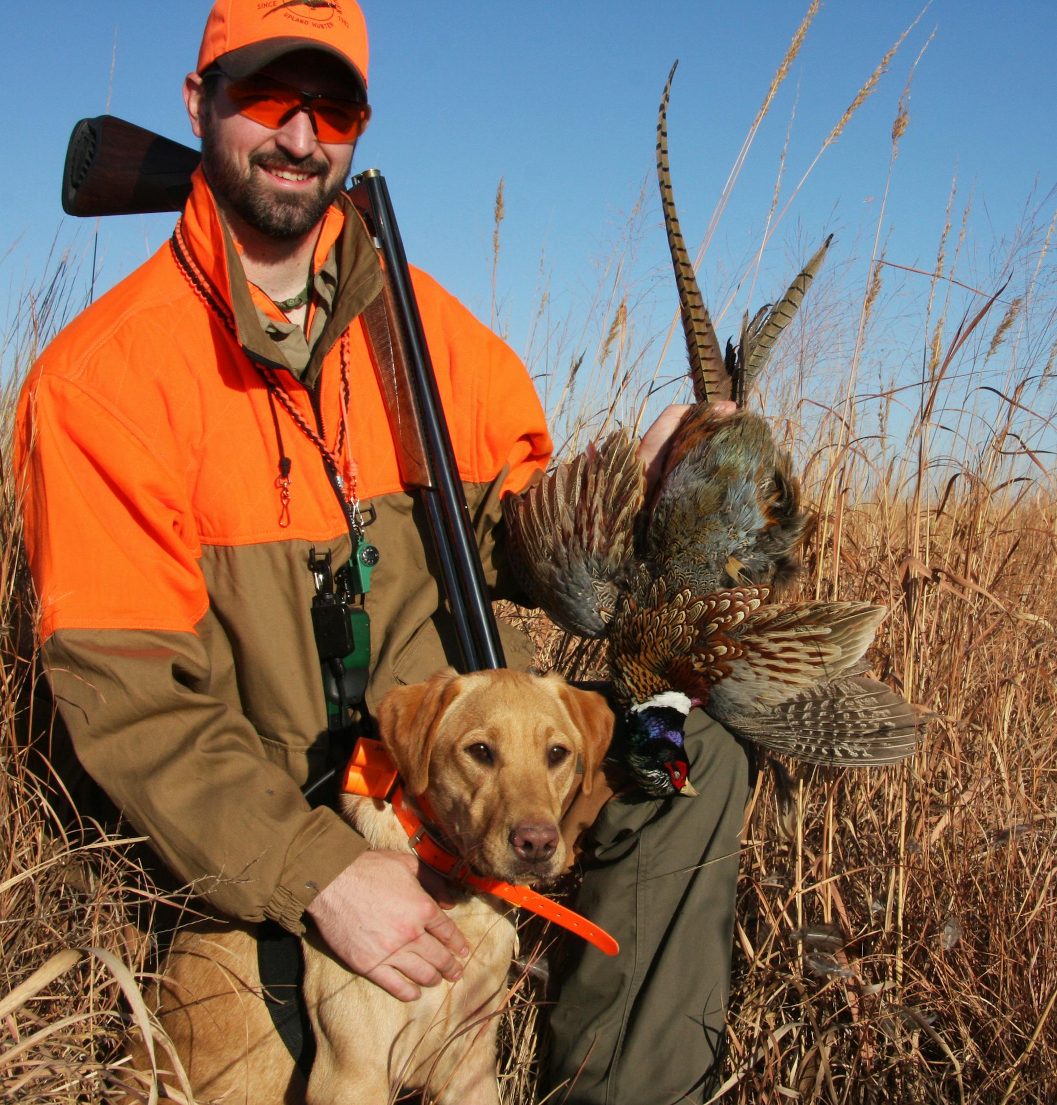 Andrew Vavra, 27, of Minneapolis and his Lab "Beau" with a rooster pheasant. Vavra and two other Pheasants Forever employees are doing a five-state-in-five-days hunting trip to underscore the benefit of creating pheasant habitat and public hunting areas.
