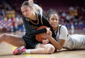 Hopkins’ Tatum Woodson (right) battles Maple Grove’s Ava Cossette for the ball during the first half of a Class 4A girls basketball state semifina