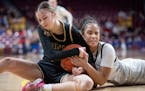 Hopkins’ Tatum Woodson (right) battles Maple Grove’s Ava Cossette for the ball during the first half of a Class 4A girls basketball state semifina