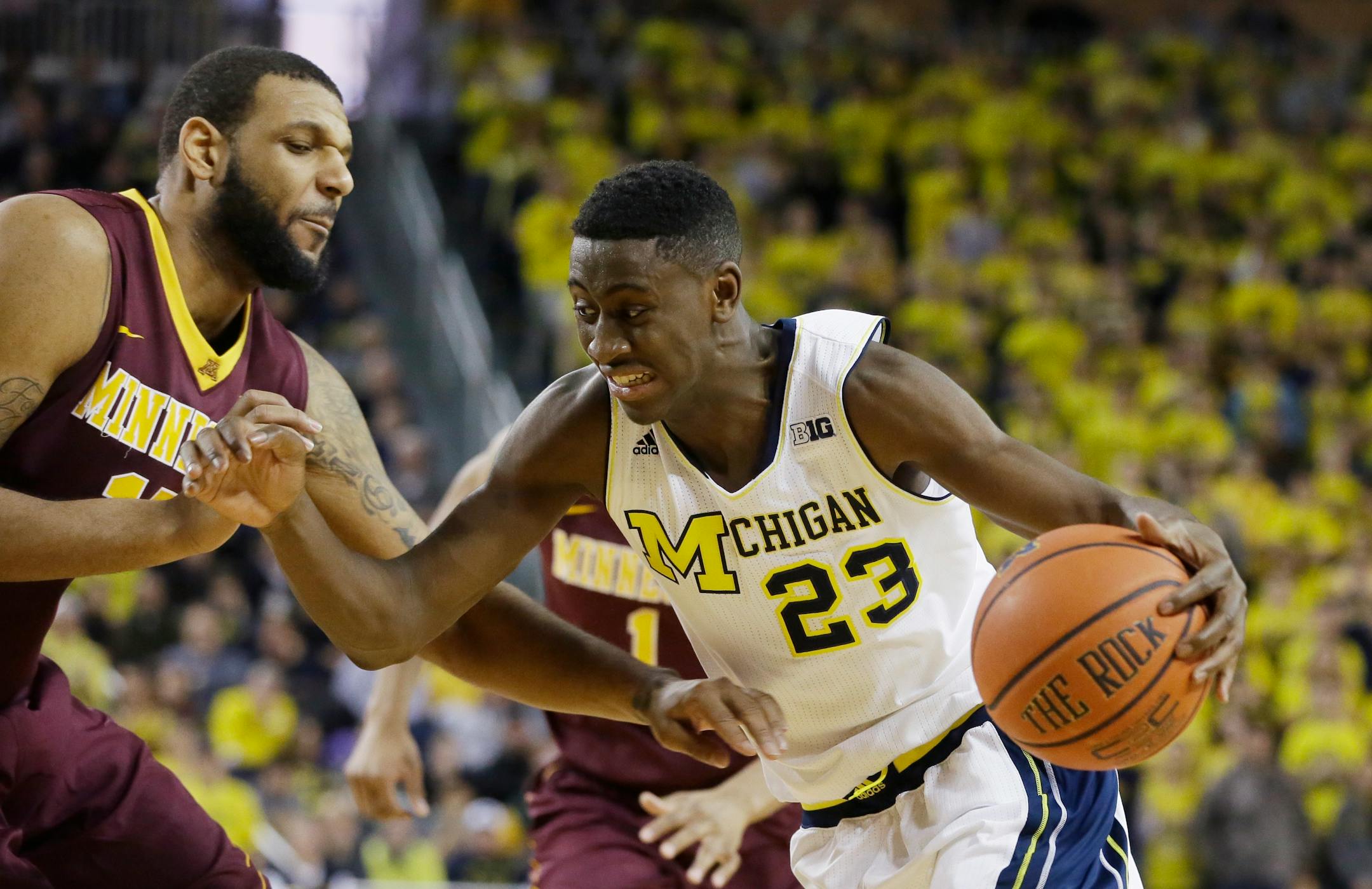 Michigan guard Caris LeVert (23) drives on Minnesota forward Maurice Walker during the second half of an NCAA basketball game, Saturday, Jan. 10, 2015, in Ann Arbor, Mich. Michigan defeated Minnesota 62-57. (AP Photo/Carlos Osorio)