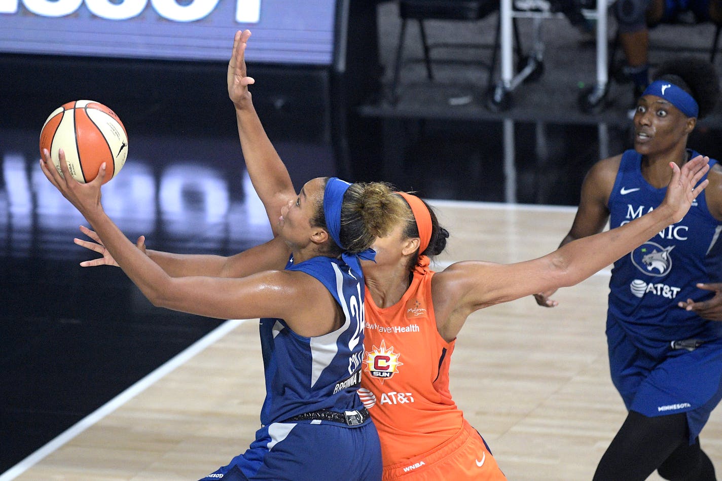 Minnesota Lynx forward Napheesa Collier (24) goes up for a shot in front of Connecticut Sun center Brionna Jones as Lynx Center Sylvia Fowles, right, watches during the second half of a WNBA basketball game, Sunday, July 26, 2020, in Bradenton, Fla. (AP Photo/Phelan M. Ebenhack)