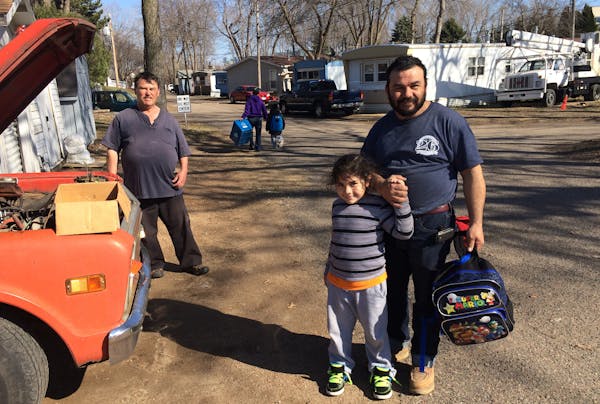 Efrain Gutierrez, right, greeted his son Ezekiel, 6, after getting dropped off by the school bus at Sun Valley mobile home park in Plymouth — neighb