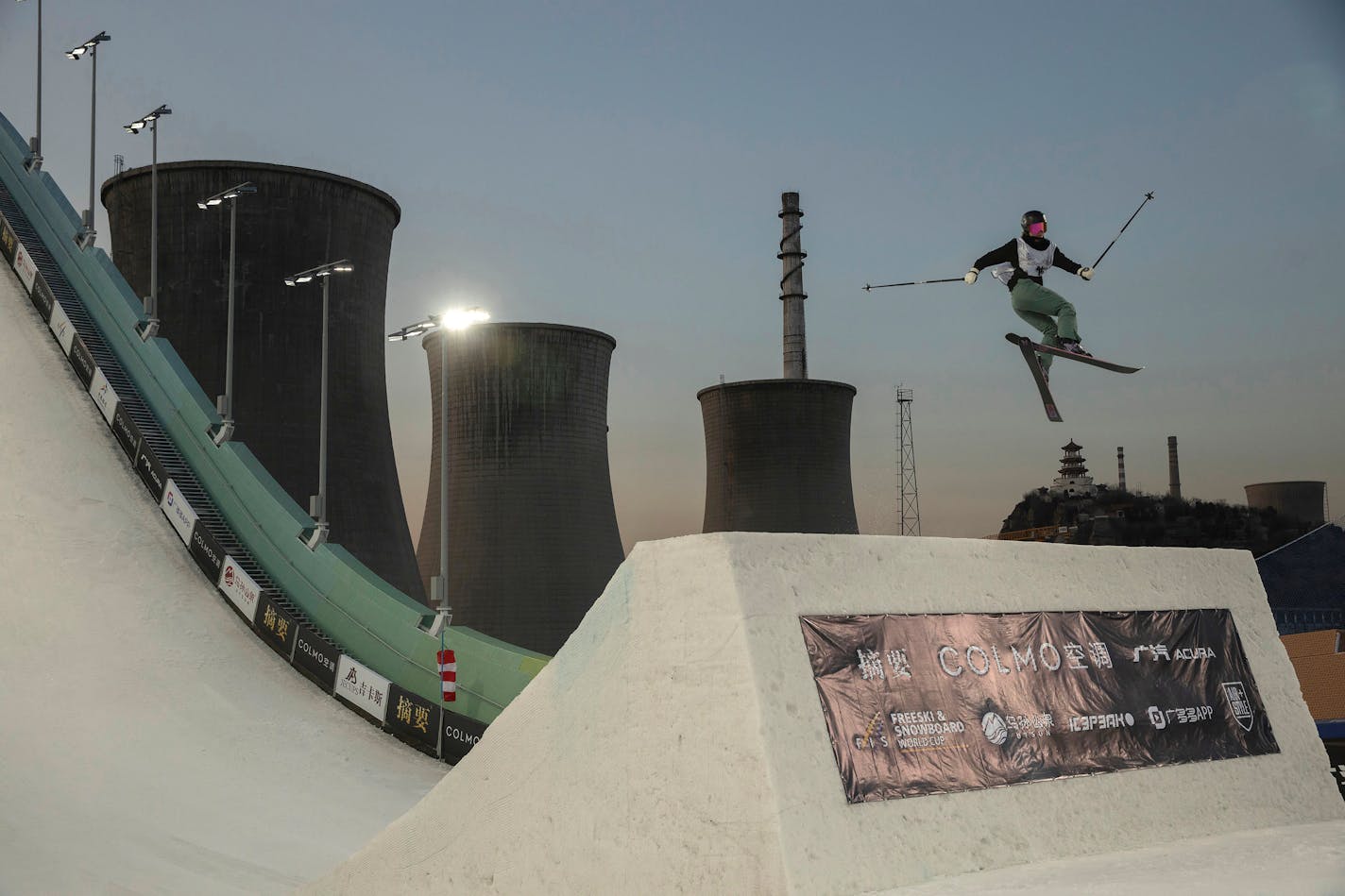 FILE - New Zealand's Margaux Hackett jumps during the Women's Freeski Big Air in the finals of the FIS Big Air World Cup at the Big Air Shougang in Beijing, Dec. 14, 2019. The venue will host the big air competition during the upcoming 2022 Beijing Winter Olympics. (AP Photo/Ng Han Guan, File)