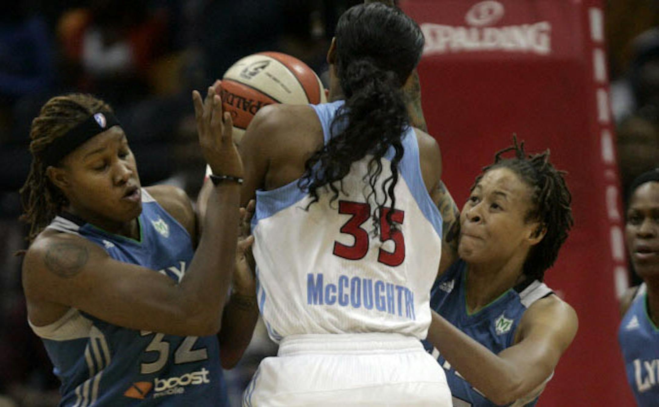 Atlanta's Angel McCoughtry, center, drives into Minnesota's Rebekkah Brunson, left, and Seimone Augustus.