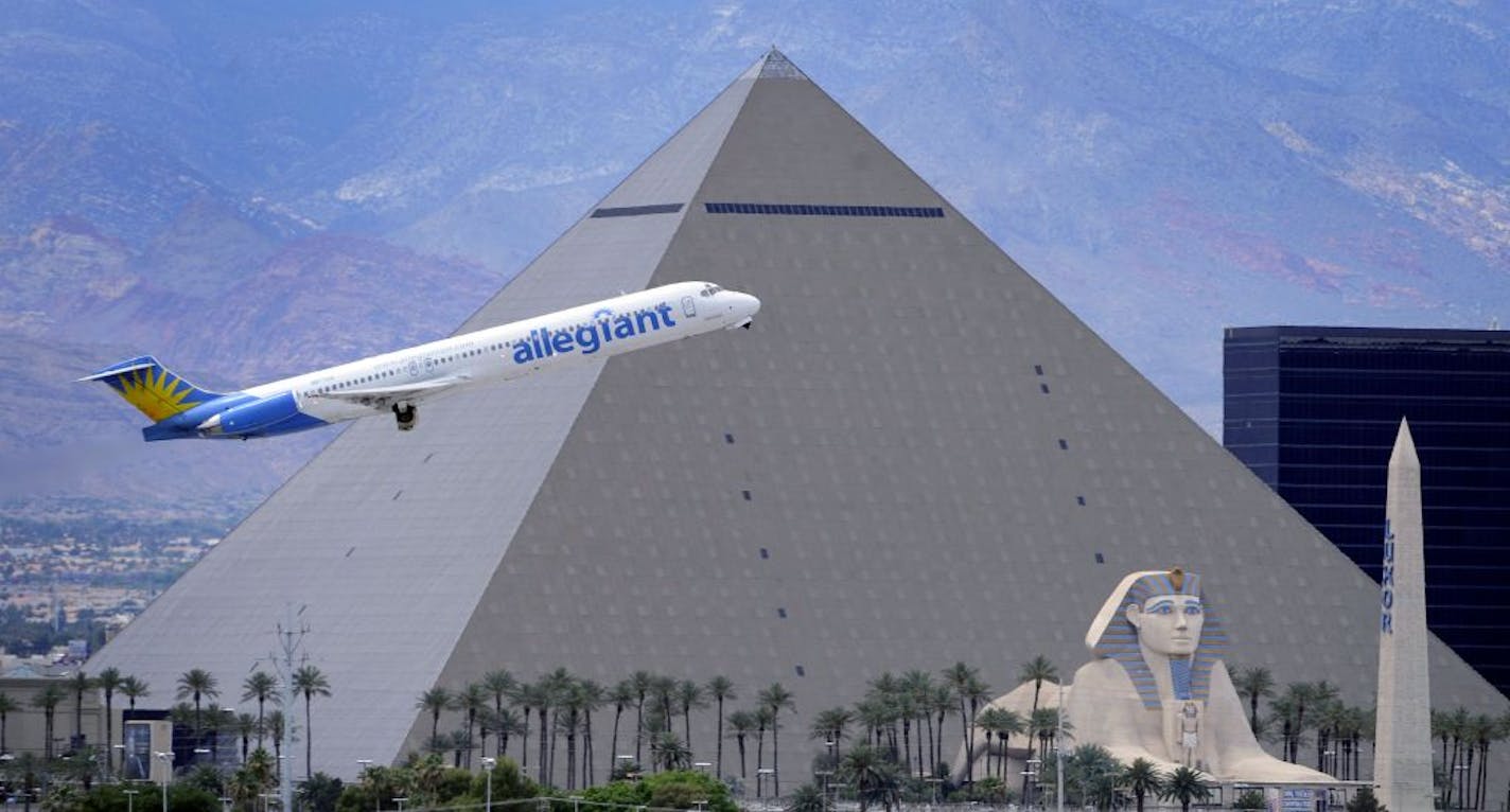 In this Thursday, May 9, 2013, photo, An Allegiant Air jetliner flies by the Luxor Resort & Casino after taking off from McCarran International Airportm in Las Vegas. While other U.S. airlines have struggled with the ups and downs of the economy and oil prices, tiny Allegiant Air has been profitable for 10 straight years.