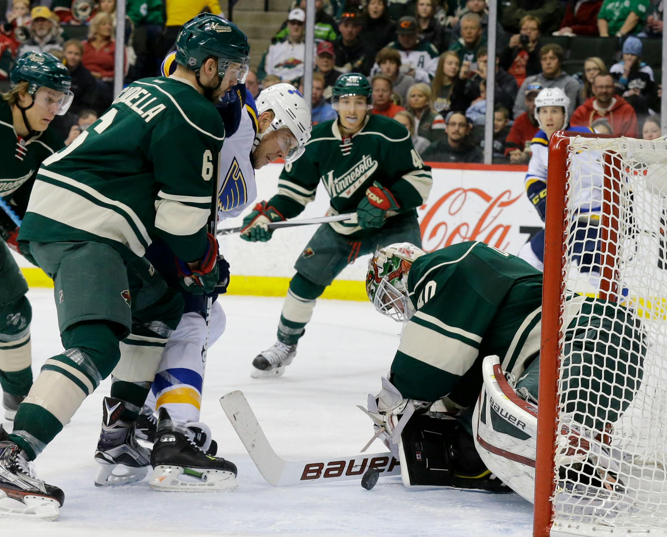 Minnesota Wild goalie Devan Dubnyk, right, deflects a shot by St. Louis Blues center Paul Stastny, center, as Wild defenseman Marco Scandella, left, covers Stastny during the second period of an NHL hockey game in St. Paul, Minn., Saturday, March 21, 2015. (AP Photo/Ann Heisenfelt)