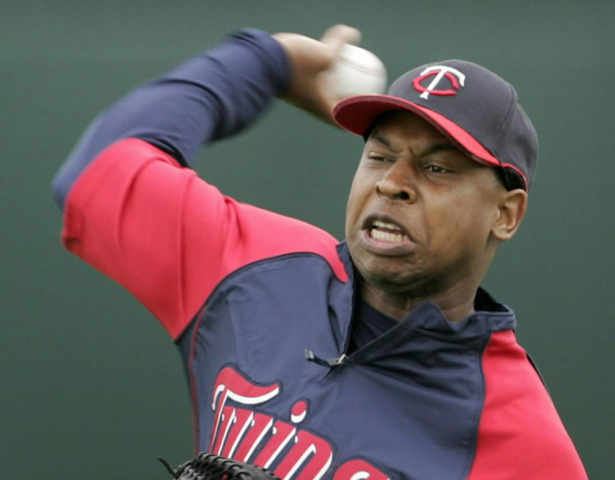 Twins outfielder Delmon Young delivers a throw while working out on the field during spring training.