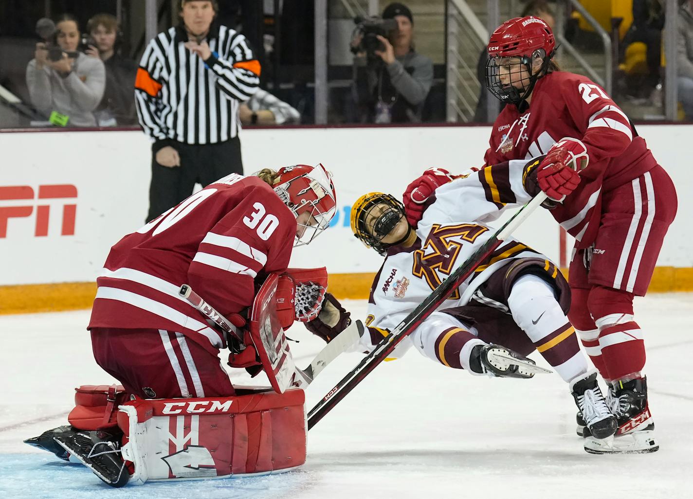 Minnesota forward Abbey Murphy (18) is brought down by Wisconsin forward Kirsten Simms (27) in front of goaltender Cami Kronish (30) in the second period of a NCAA Frozen Four semifinal game at Amsoil Arena in Duluth, Minn., on Friday, March 17, 2023. Minnesota faced Wisconsin in a semifinal game to advance to the championship game at the NCAA Frozen Four. ] SHARI L. GROSS • shari.gross@startribune.com