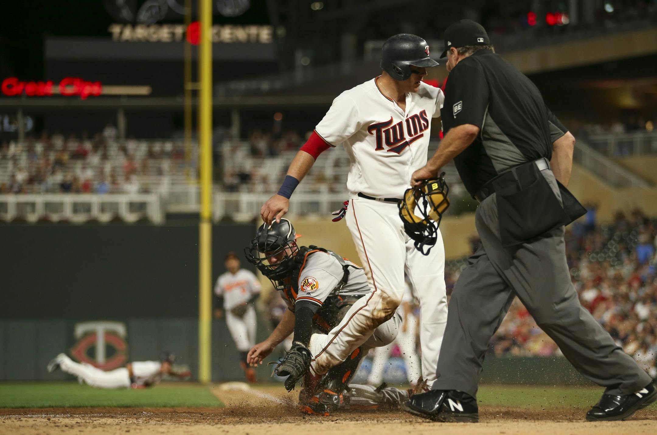 Minnesota Twins first baseman Logan Morrison slid safely home ahead of the tag by Orioles catcher Caleb Joseph in the eighth inning. Morrison scored on a single by Max Kepler.