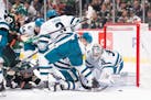 San Jose Sharks goaltender Kaapo Kahkonen (36) reaches for a loose puck as players pile up in the second period. The Minnesota Wild faced the San Jose
