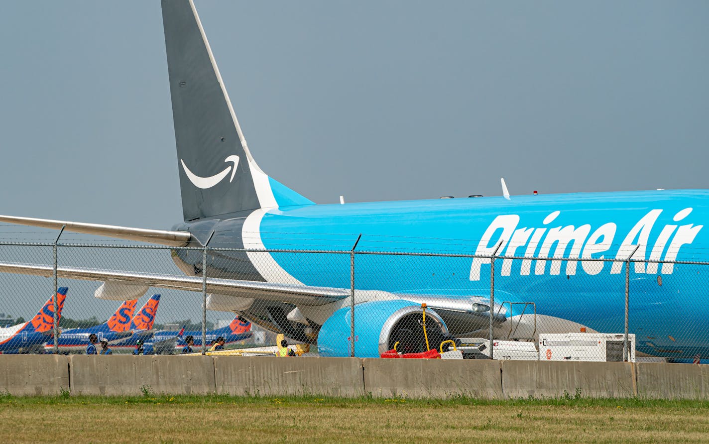 Workers unloaded a Prime Air jet after it landed at Minneapolis-St. Paul International Airport. Sun Country's deal with Amazon is helping the airline fight through an industrywide downturn.