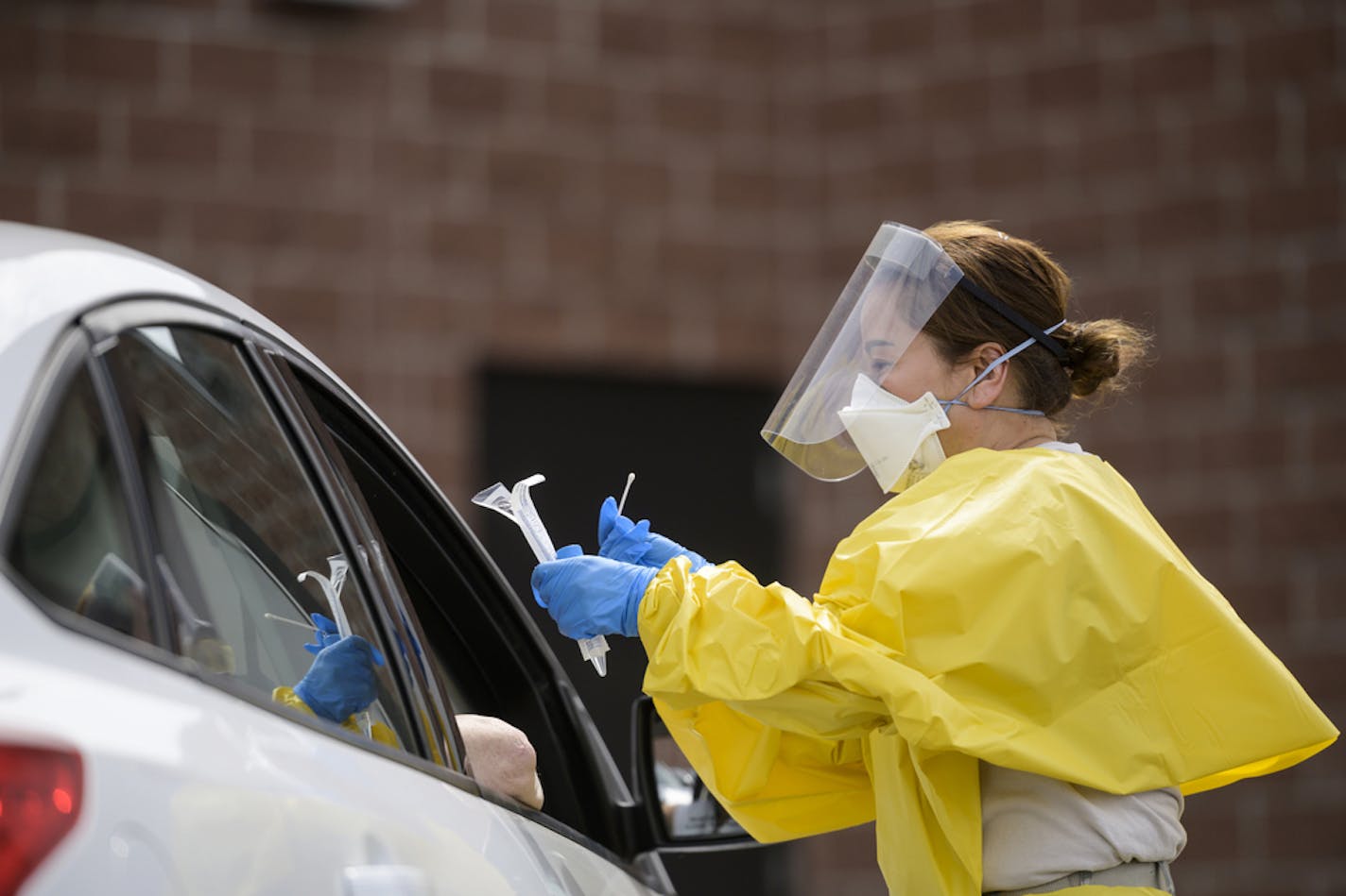 Elizabeth Santoro, a medic with the Minnesota Air National Guard 133rd Medical Group, administered a free COVID-19 test to a passenger at the drive-up testing site behind the Minneapolis Armory, Saturday, May 23, 2020, in Minneapolis. The Minnesota National Guard offered free COVID-19 testing at the Minneapolis Armory. Several free testing locations across the state were operated by the National Guard, the Minnesota Dept. of Health and the State Emergency Operations Center. (Aaron Lavinsky/Star