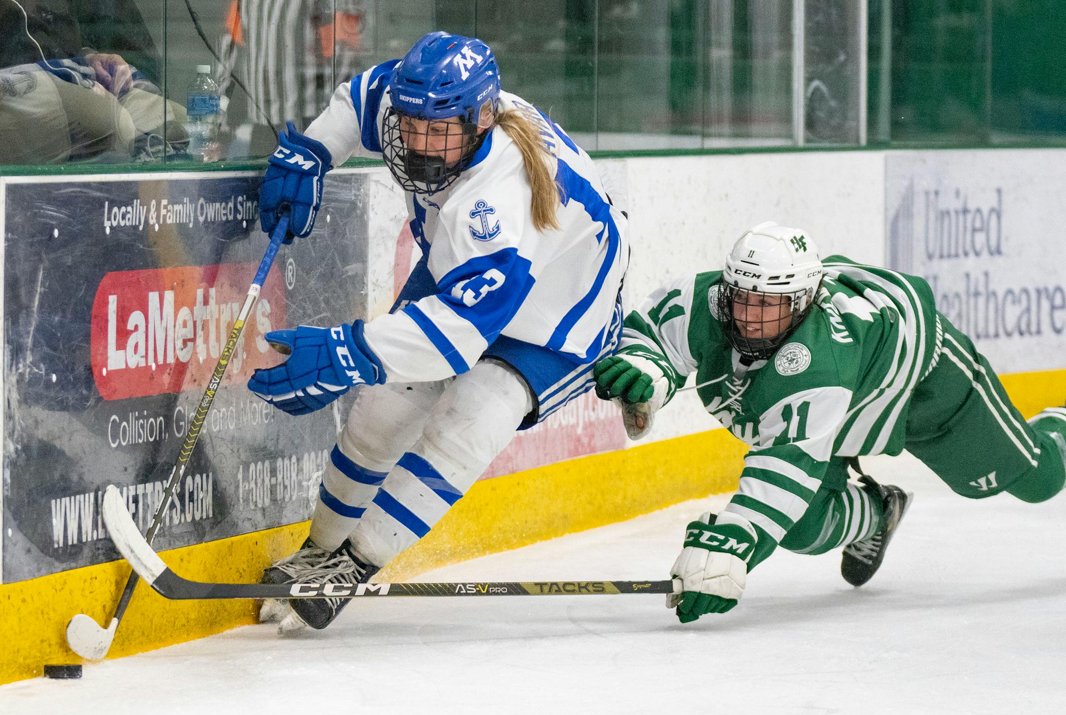 Minnetonka forward Lindzi Avar (13) carries the puck past Holy Family defender Ella Knewtson (11) during the first period.