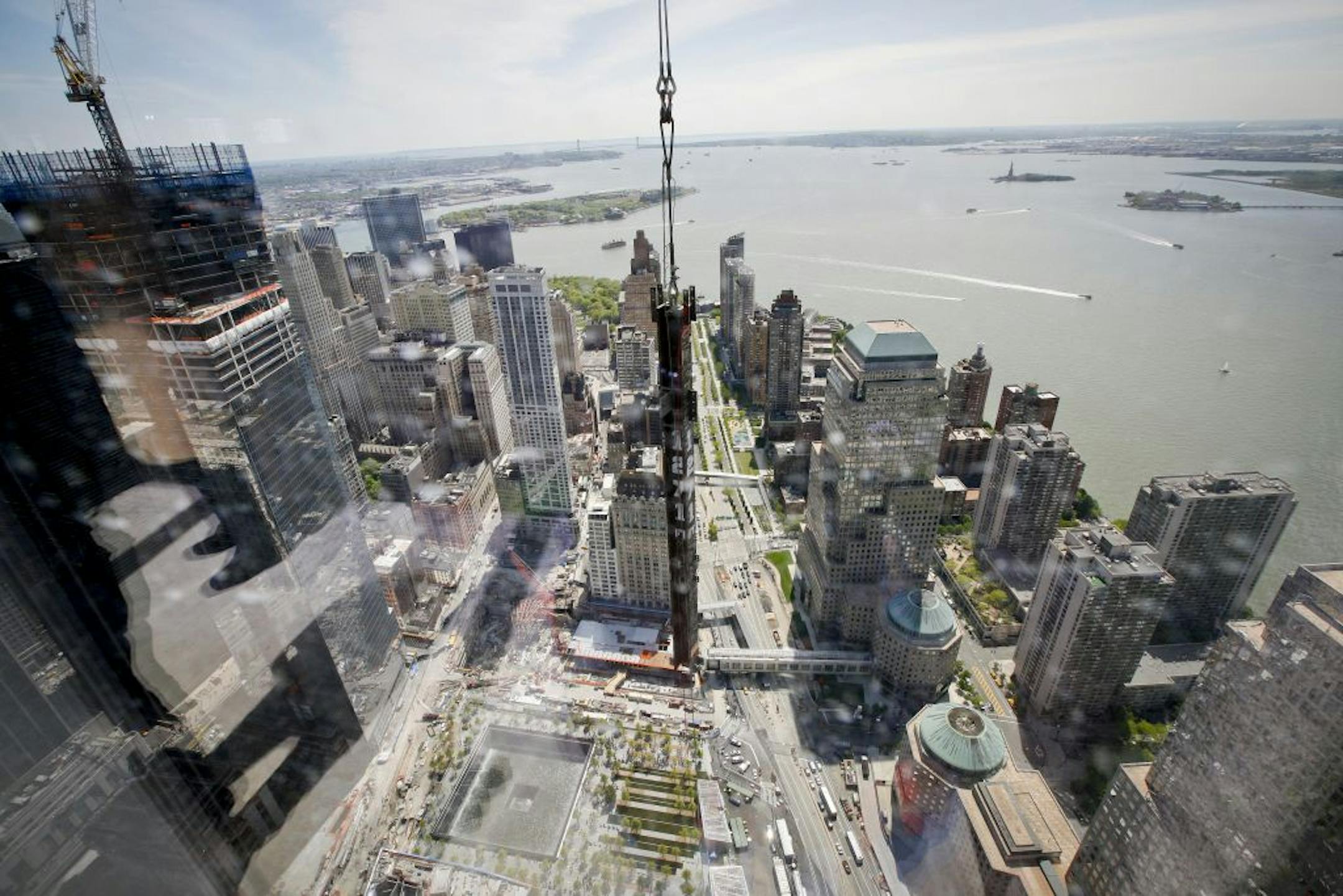 A beam is raised to the top of One World Trade Center, with a World Trade Center tower footprint visible below, in New York, on April 30, 2012. With the beam placed to begin the 100th floor, the tower became the tallest in New York, surpassing the Empire State Building.