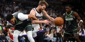 The Timberwolves' Karl-Anthony Towns and the Kings' Domantas Sabonis vie for control of a loose ball in the first quarter.