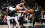 The Timberwolves' Karl-Anthony Towns and the Kings' Domantas Sabonis vie for control of a loose ball in the first quarter.