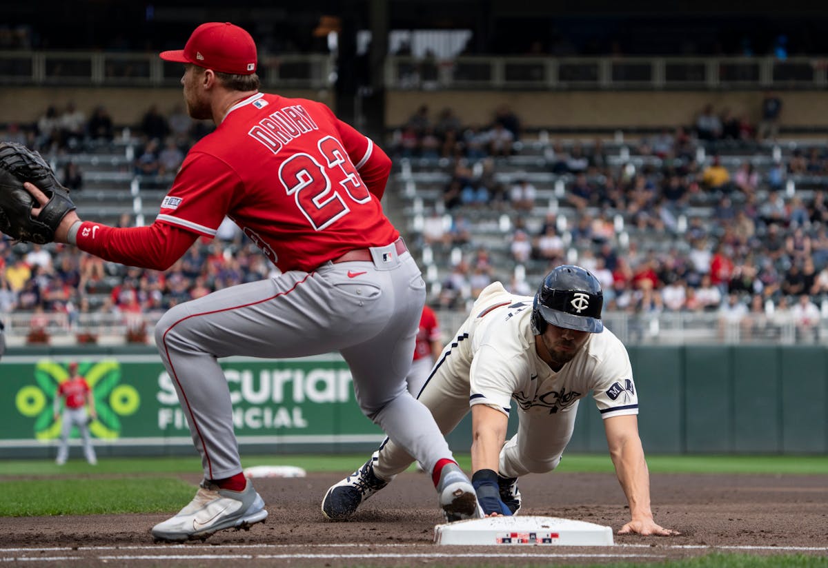 Minnesota Twins first baseman Alex Kirilloff (19) slides safely back to first base against Los Angeles Angels first baseman Brandon Drury (23) in the 
