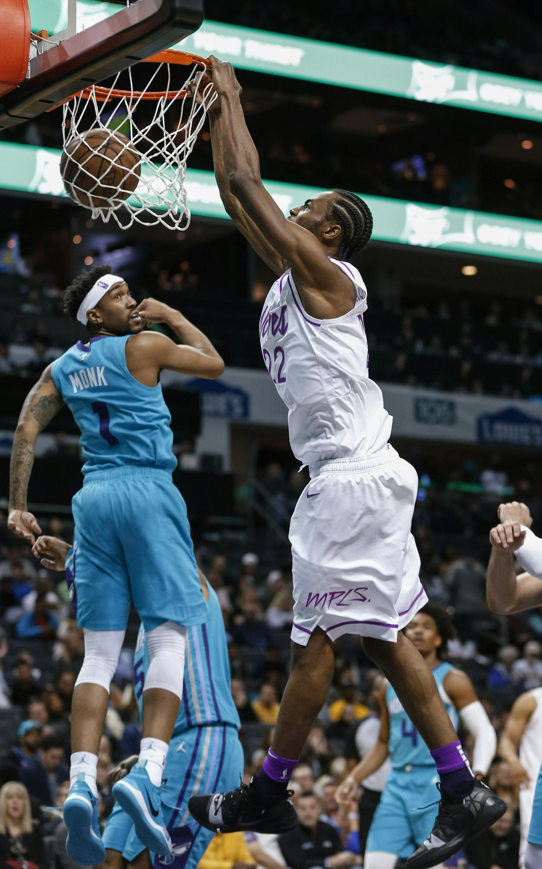 Minnesota Timberwolves forward Andrew Wiggins, center, dunks as Charlotte Hornets guard Malik Monk, left, and center Willy Hernangomez watch during the second half of an NBA basketball game in Charlotte, N.C., Thursday, March 21, 2019. Charlotte won 113-106. (AP Photo/Nell Redmond)
