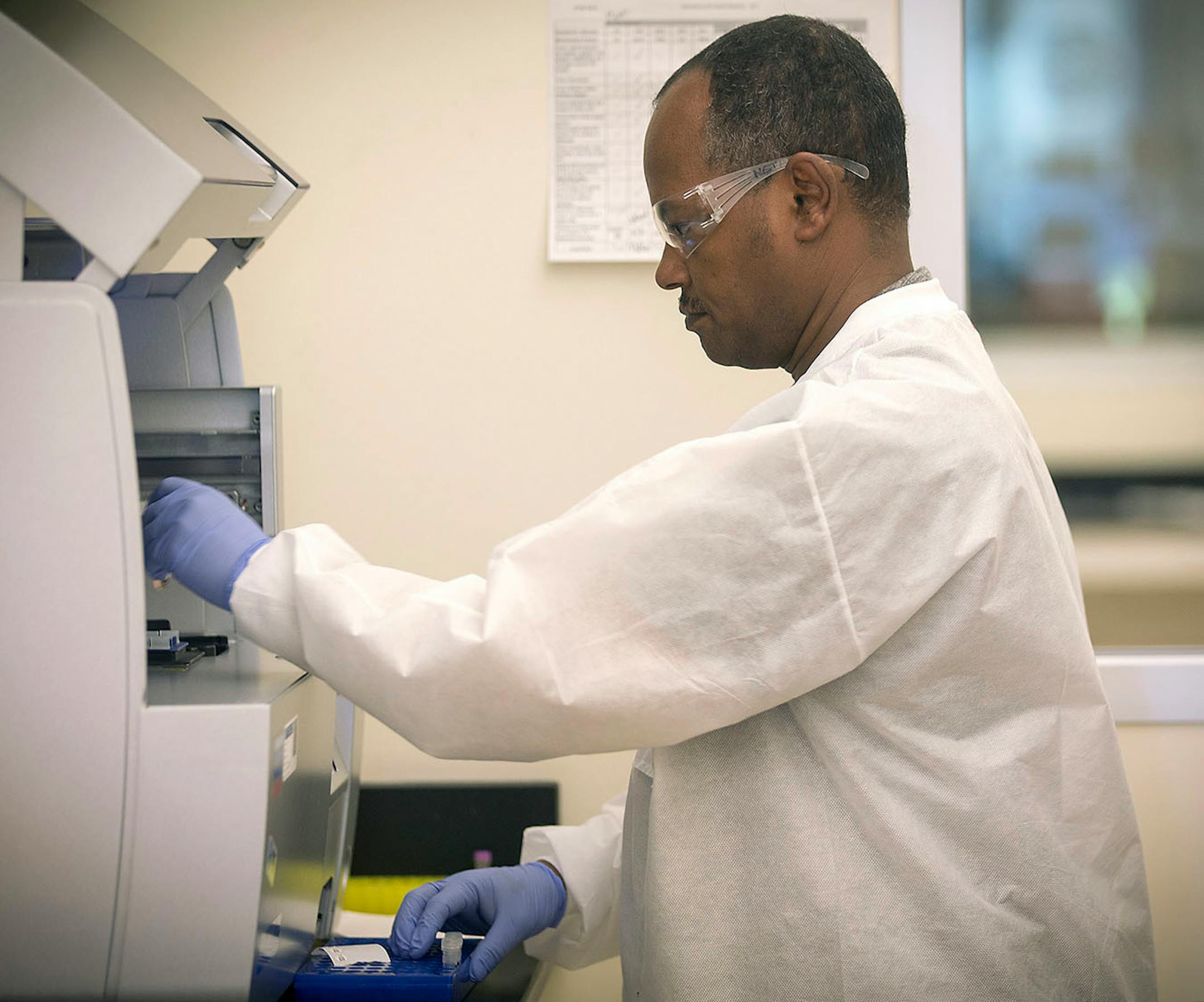 Netsanet Bekele, cq, a clinical lab scientist for the Minnesota Health Department test for measles as he places the tubes into a robot, Thursday, May 11, 2017 at the MHD laboratories in St. Paul, MN.