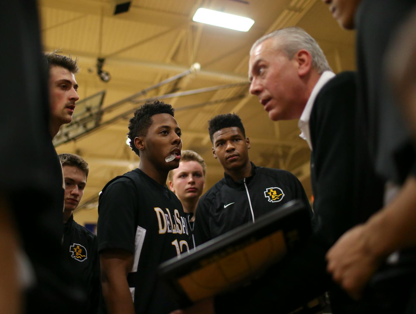 Jarvis Johnson (12) and his teammates listened to their head coach, Dave Thorson, explain the game plan before the tipoff against Fridley. ] JEFF WHEELER • jeff.wheeler@startribune.com DeLaSalle High School trounced Fridley 69-31 in a boy's basketball game Thursday night, February 12, 2015 at DeLaSalle. The Islanders' Jarvis Johnson is the top preps hoops player in the state and the Gophers' No. 1 recruit for 2015.