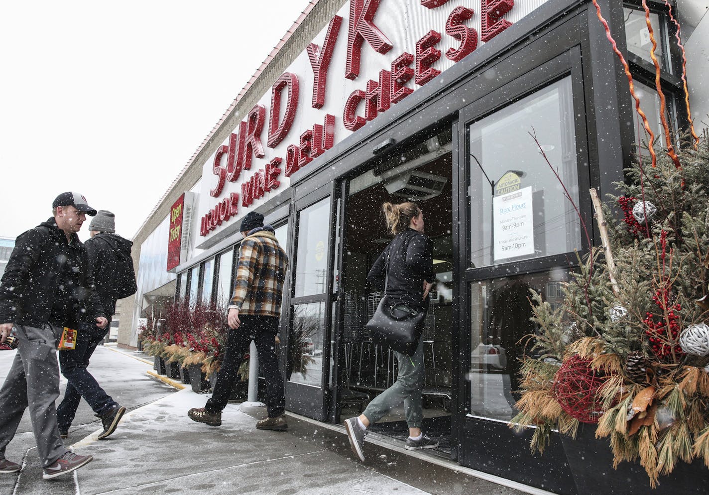 People enter Surdyk's in the snow on Sunday, March 12. Surdyk's, opened for business Sunday, despite Minnesota&#x2019;s new Sunday liquor sales law not taking effect until July.