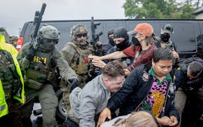 Protesters confront law enforcement as they try to remove someone detained outside Los Cuatro Milpas restaurant in Minneapolis.