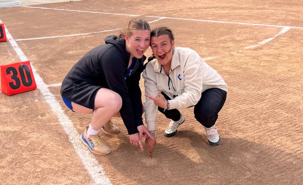 Cambridge-Isanti shot putters Evelyn Wiltrout (left) and Erin Baker posed over the mark Wiltrout’s shot made on her winning throw at the Mississippi