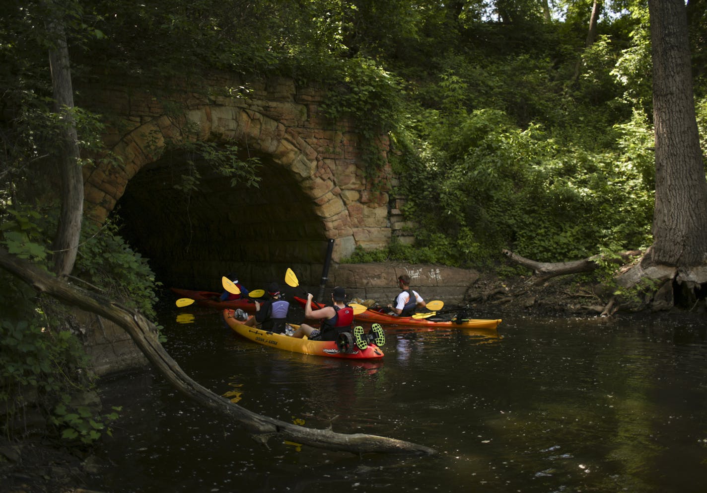 Guide Theo Burns of Above the Falls Sports, right, led Jelena Radojevic and Joe Doherty of Australia, foreground, and Michael Turner of Tampa from the Mississippi River into the underground stretch of Bassett's Creek.