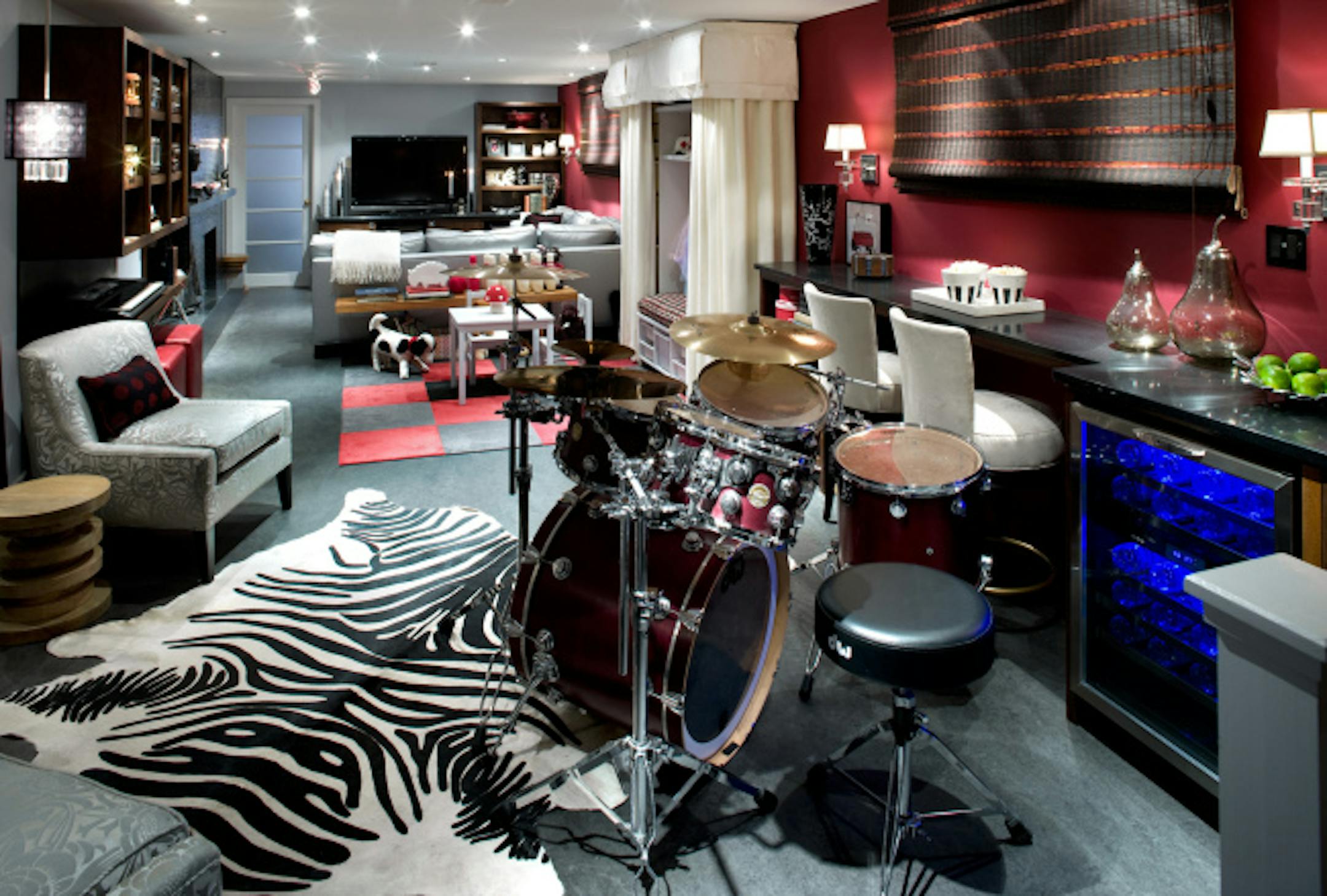 The home's husband can drum by himself, then lounge with the family on the comfy sectional. Metallic and red and black accents complete the vibe.