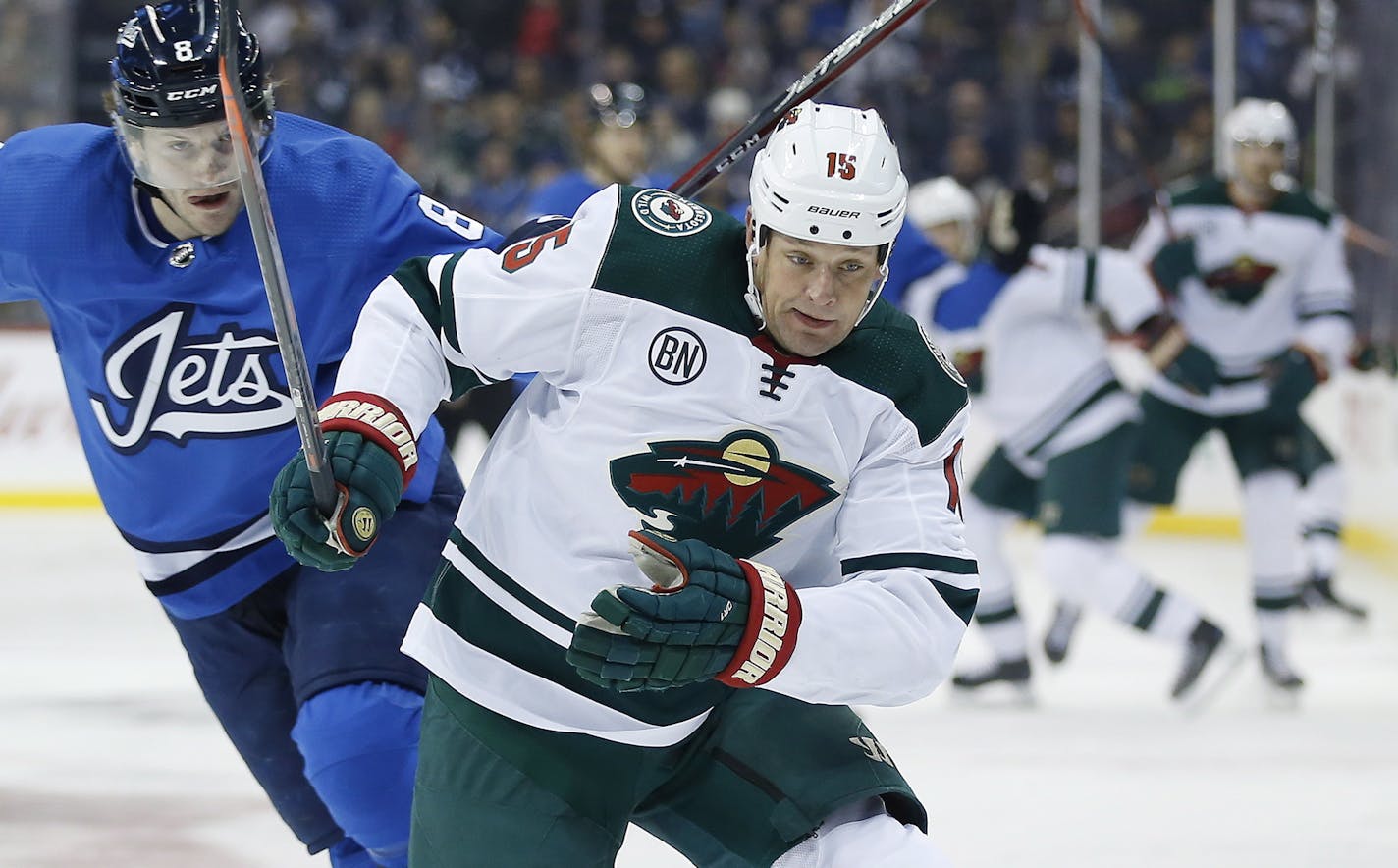 Winnipeg Jets' Jacob Trouba (8) can't stop Minnesota Wild's Matt Hendricks (15) as he skates past during first period NHL action in Winnipeg, Manitoba, on Saturday, Dec. 29, 2018. (John Woods/The Canadian Press via AP)