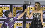 Director Taika Waititi hands the Thor hammer to Natalie Portman during the "Thor Love And Thunder" portion of the Marvel Studios panel on day three of