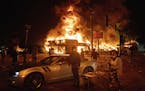 An AutoZone store burns as protesters gather outside of the Third Precinct in Minneapolis Thursday, May 28, 2020. Police say a man captured on surveil
