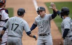 Seattle third baseman Kyle Seager (15) celebrated his three-run homer in the ninth inning with Mitch Haniger, left, and Ty France.
